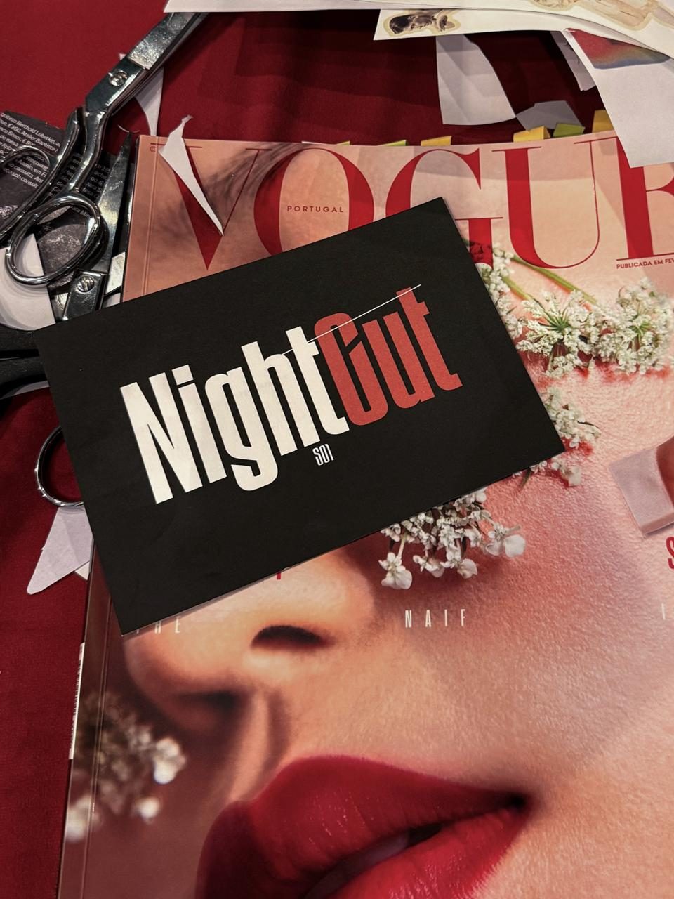 The black NightCut S01 card resting on a Vogue Portugal cover, beside scissors and freshly cut scraps.